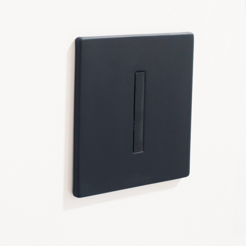 Válvula de descarga automática para urinario con frontal negro, para instalación empotrada.